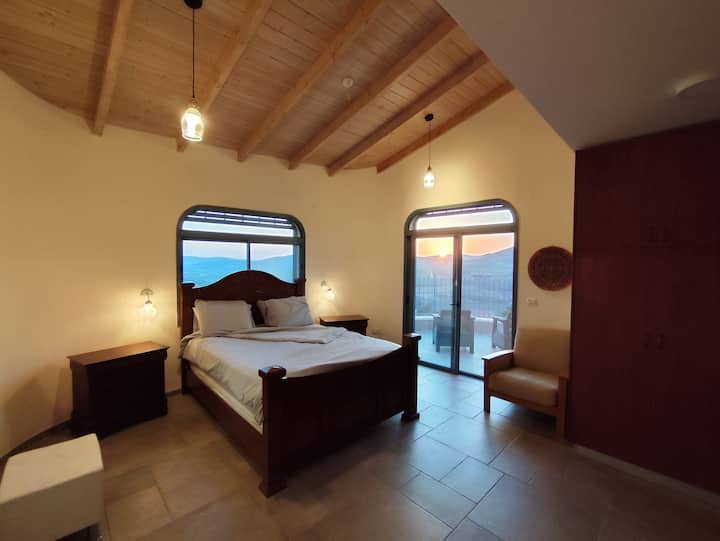 Главна спалня на втория етаж с балкон с изглед към планините на Долна Галилея и долината. Насладете се на спокойните залези, докато седите на балкона и пиете чаша вино.