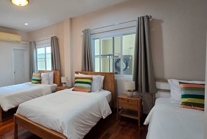 Dhomë në katin përdhes me 3 krevate tek dhe banjë ngjitur.