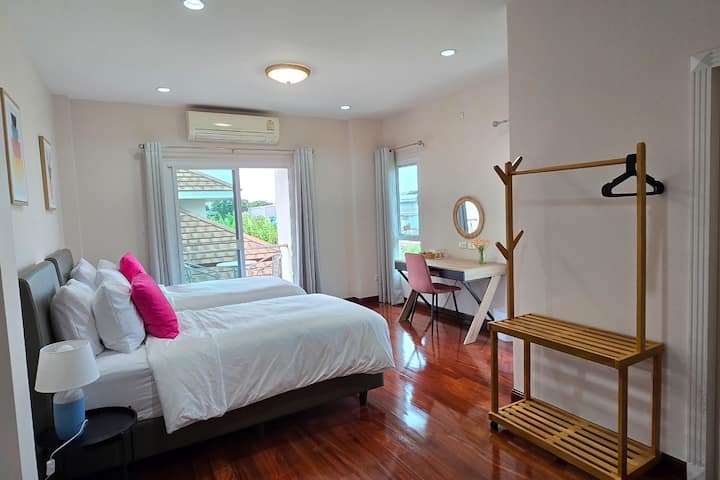 Dhoma e gjumit e ajrosur me dy krevate dopio dhe ballkon privat me pamje nga pishina.