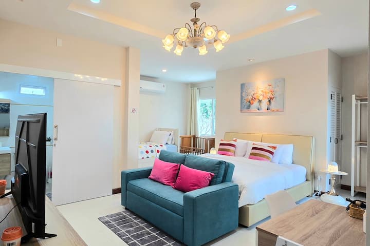 Dhomë e gjerë në katin përdhes me krevat dopio "king" dhe krevat tek, një divan krevat, televizor  dhe suitë, e përshtatshme për familje dhe karrige me rrota.