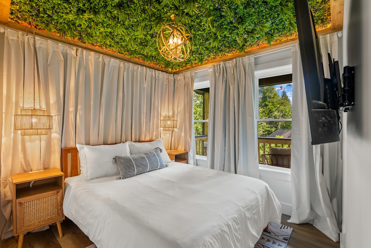 Lala chini ya turubai ya kijani katika chumba hiki cha kulala chenye utulivu, kilichojaa majani yanayong 'aa na muundo wa starehe, wa kisasa.