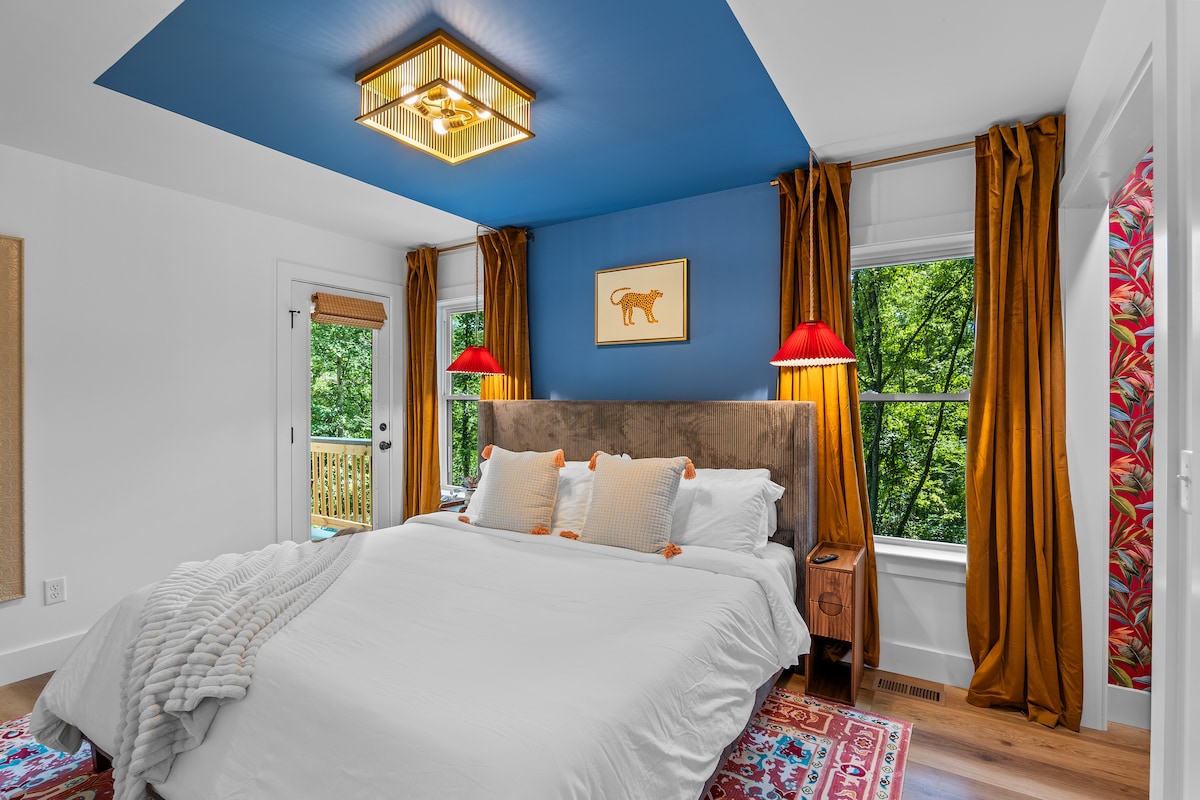 Lala kimtindo ukiwa na mwangaza mahususi, ubao wa kichwa wa velvet na suti yenye rangi mbalimbali ambayo inaonekana kama hoteli mahususi.