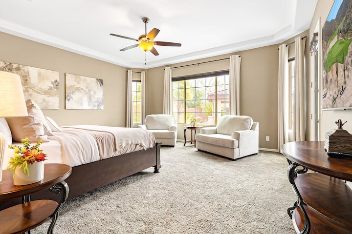 Une suite parentale spacieuse avec salle de bain privée et accès direct à l'arrière-cour et à la piscine allie luxe, confort et intimité.