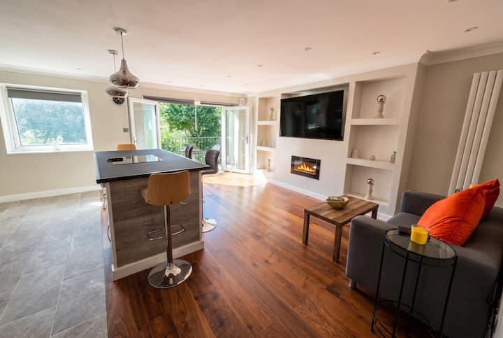 Open plan living with a cosy fire and garden views just beyond the doors