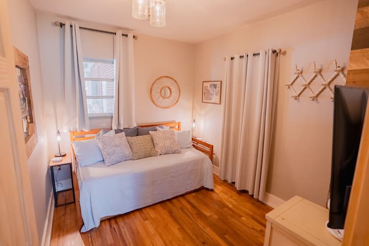 Cozy bedroom with a daybed and trundle, hardwood floors, soft lighting, and simple décor. A comfortable space ideal for kids or additional guests.