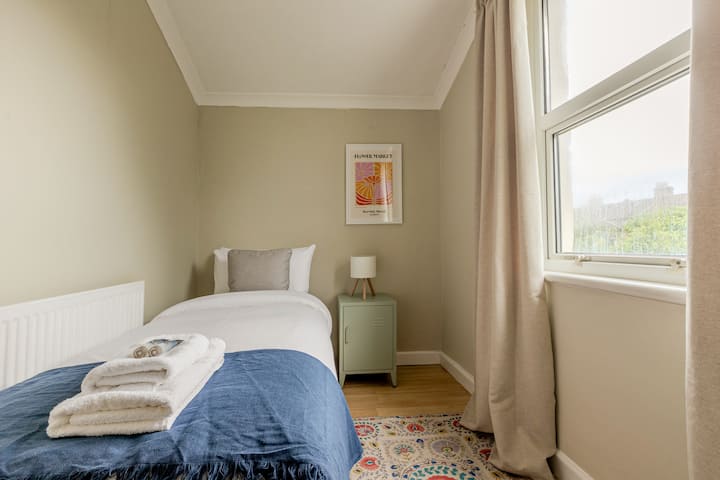 Jedna spálňa: slnkom zaliata izba s jednolôžkom, mäkkou bielizňou a minimalistickou výzdobou – ideálna pre jedného hosťa alebo dieťa.