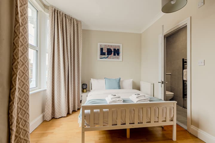 Hlavná spálňa s vlastnou kúpeľňou: veľkoryso veľká hlavná spálňa s plyšovou manželskou posteľou, mäkkými textúrami a vlastnou kúpeľňou s sprchovacím kútom a moderným povrchom.