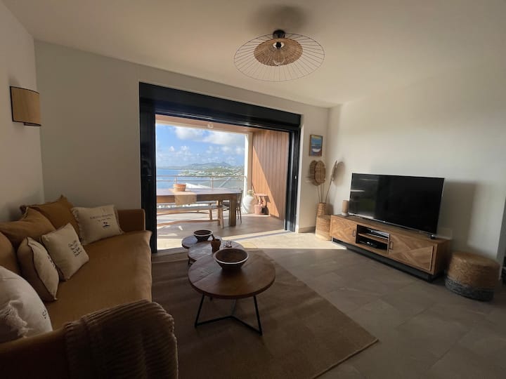 Уютна всекидневна с изглед към морето, спокойна атмосфера и изключителна панорама от дивана! Перфектно за тропическите ви вечери.