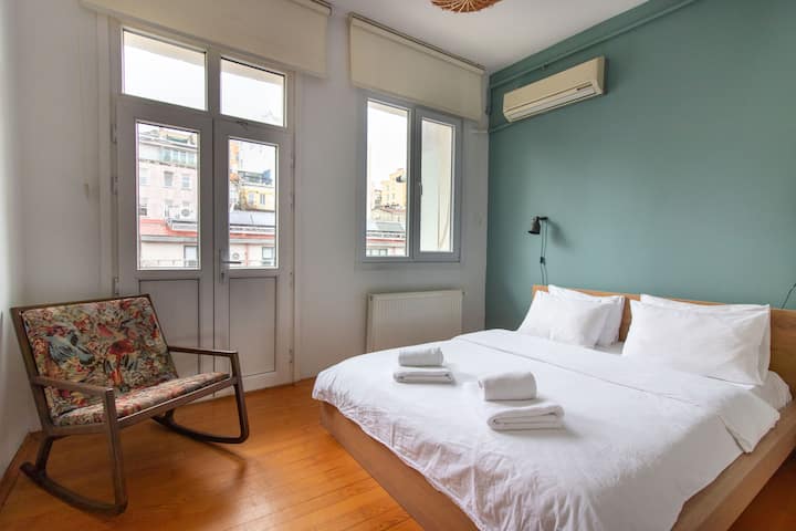 Dhomë gjumi e qetë me një krevat dopio, ajër të kondicionuar dhe një mur të gjelbër të butë.
