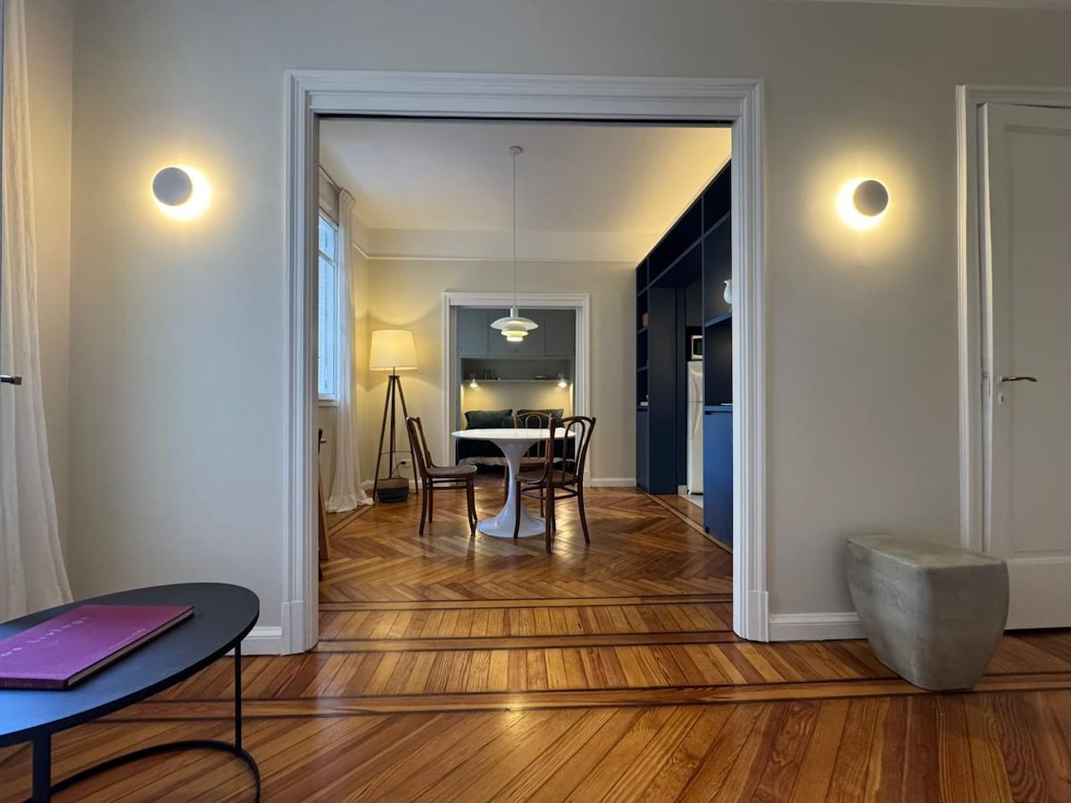 Bright, appealing interior with a clear whole-room view of the dining/living area and a visible connection to the bedroom alcove, which helps travelers understand the unit layout.