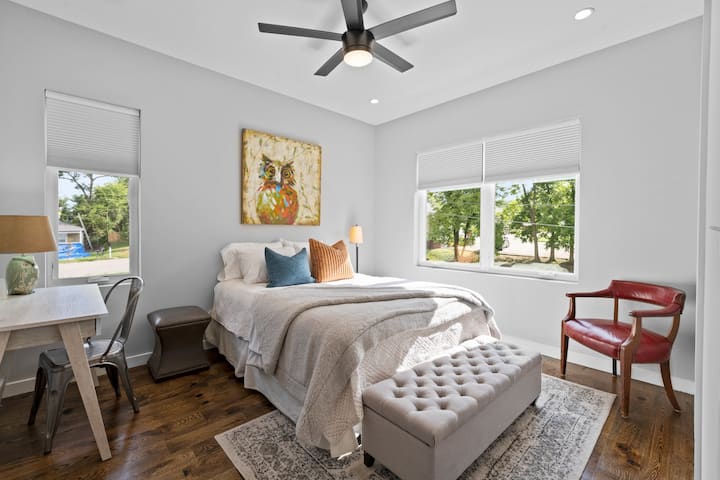 Опуштете се во спокојната главна спална соба со удобен брачен кревет (широк 150-179 см), паметен телевизор, тавански вентилатор, плакар, канцелариско биро, клупа за складирање, ноќни шкафчиња, приклучок за полнење и машина за бела бучава. 