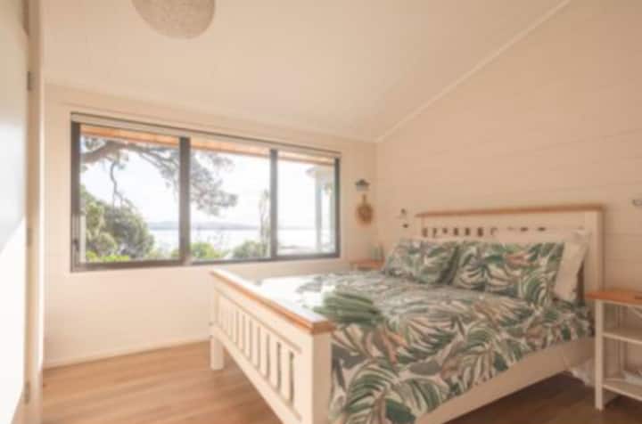 Queen bedroom two with views of Pohutukawa and harbour.