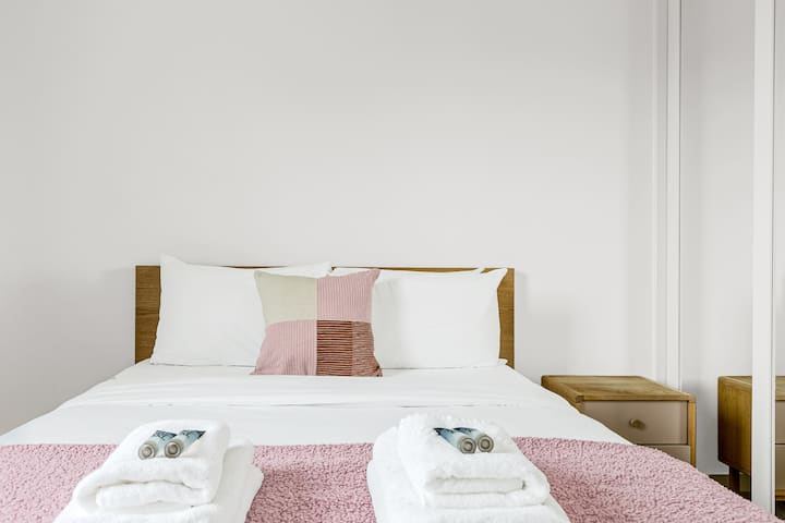 חדר שינה נוח ומצויד היטב עם מצעים רכים ואחסון, המציע מקום מפלט מרגיע.