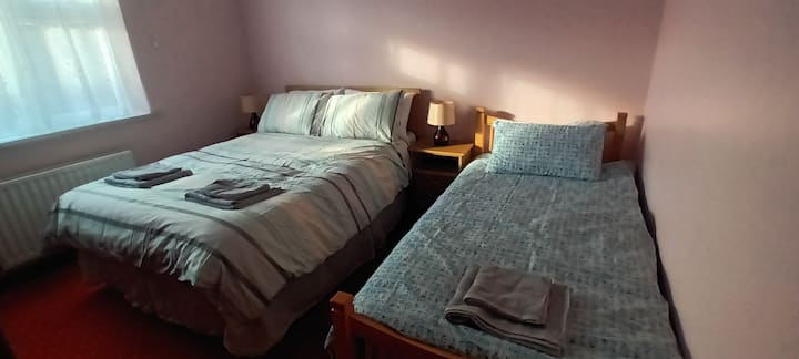 Trojlôžková spálňa s jednou manželskou a jednou samostatnou posteľou.