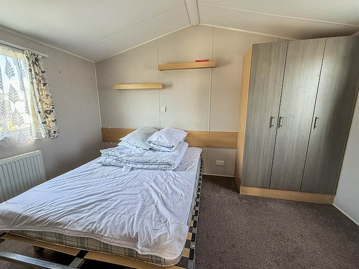 El dormitorio de la caravana es un refugio acogedor, perfecto para relajarse después de un día de playa.
