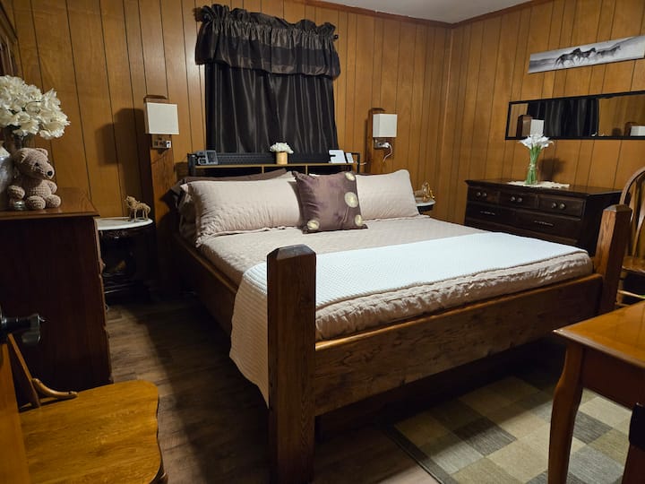Esta habitación cuenta con una cama tamaño king, hecha a mano por el padre de los anfitriones en la década de 1970. Hay un mini-split para el control de clima personalizado, así como un televisor inteligente grande. Los enchufes y tomas USB están integrados en las lámparas de los postes. 