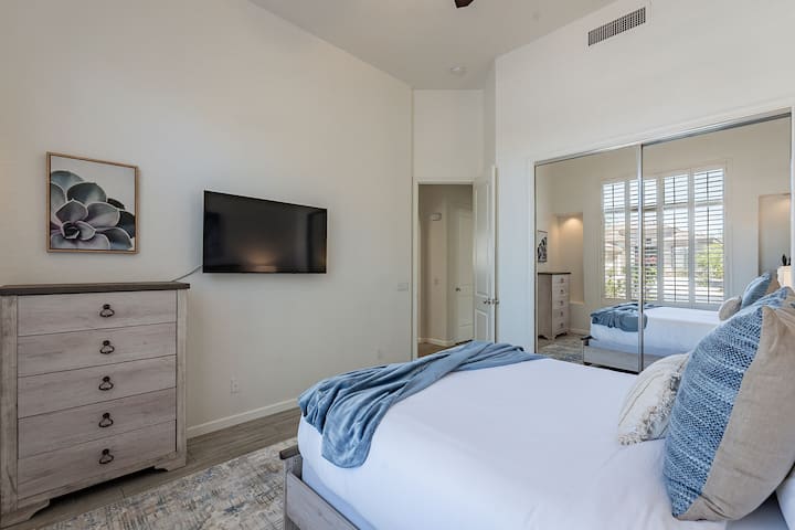 سرير بحجم متوسط وخزانة وتلفزيون ذكي في غرفة النوم الثانية