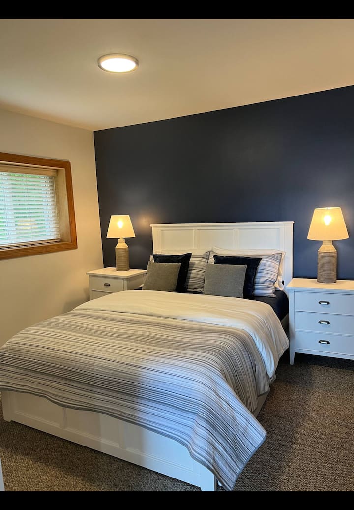 Bračni krevet s bočnim stolićima koji imaju utičnice i USB priključke.  U ovoj spavaćoj sobi nalazi se ogledalo u punoj veličini i prostrani ormar s policama i vješalicama.