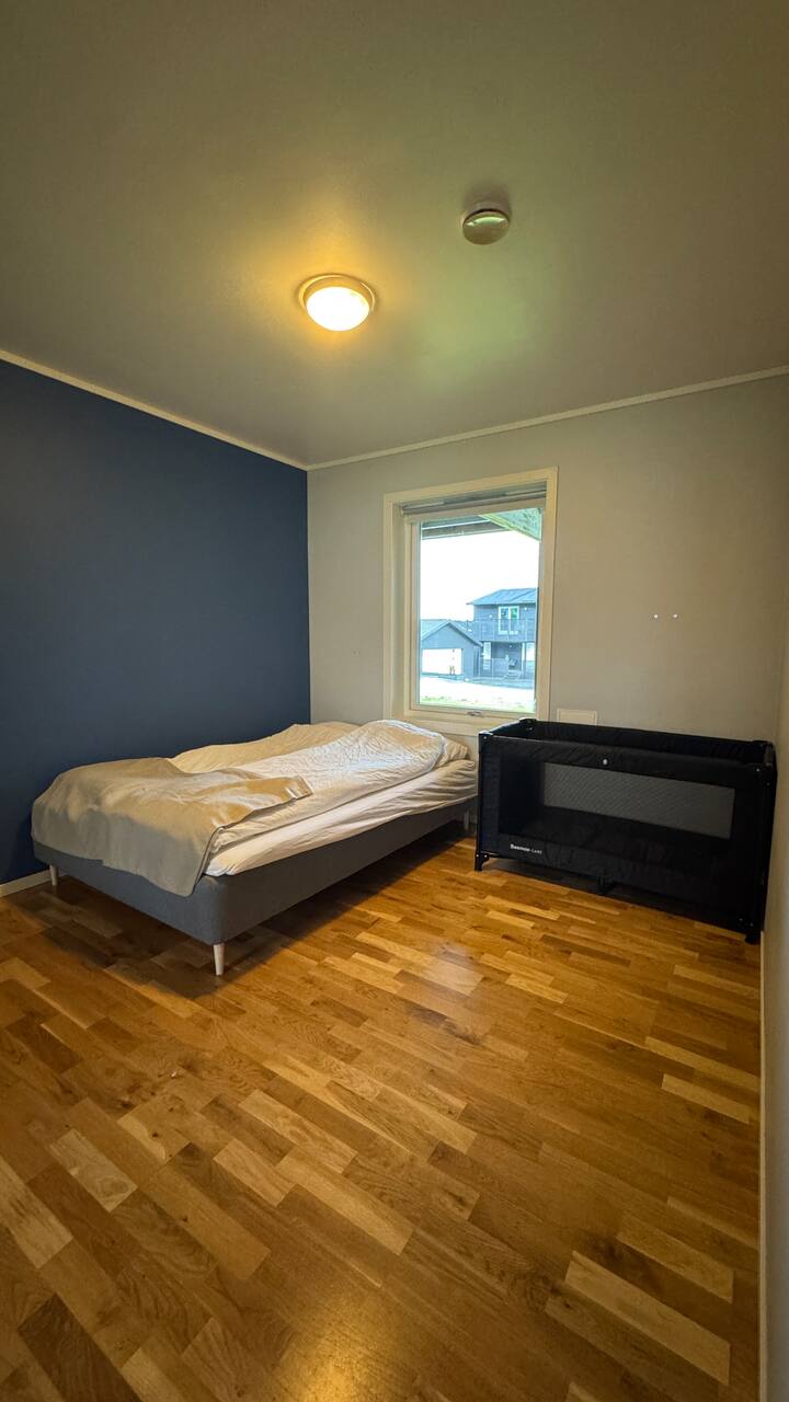 غرفة نوم كبيرة مع سرير مقاس كينج (180 × 200 سم) وسرير أطفال (60 × 120 سم، بحد أقصى 15 كجم).