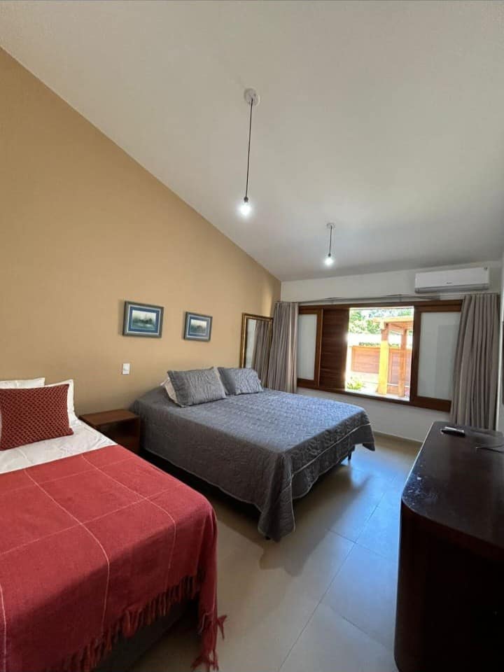 חדר שינה ראשי מרווח ואוורירי עם מיזוג אוויר, מיטת יחיד ומיטת קינג סייז. יש בו ארון גדול.