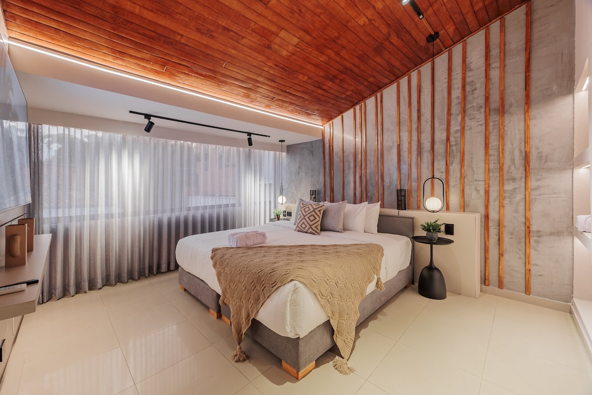 חדר שינה אלגנטי עם מיטת קינג סייז, חדר רחצה צמוד פרטי, מיזוג אוויר וטלוויזיה חכמה - מרווח, מעודן ומעוצב לנוחות מוחלטת