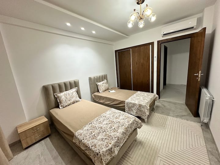Habitación con dos camas individuales, aire acondicionado y un gran armario empotrado