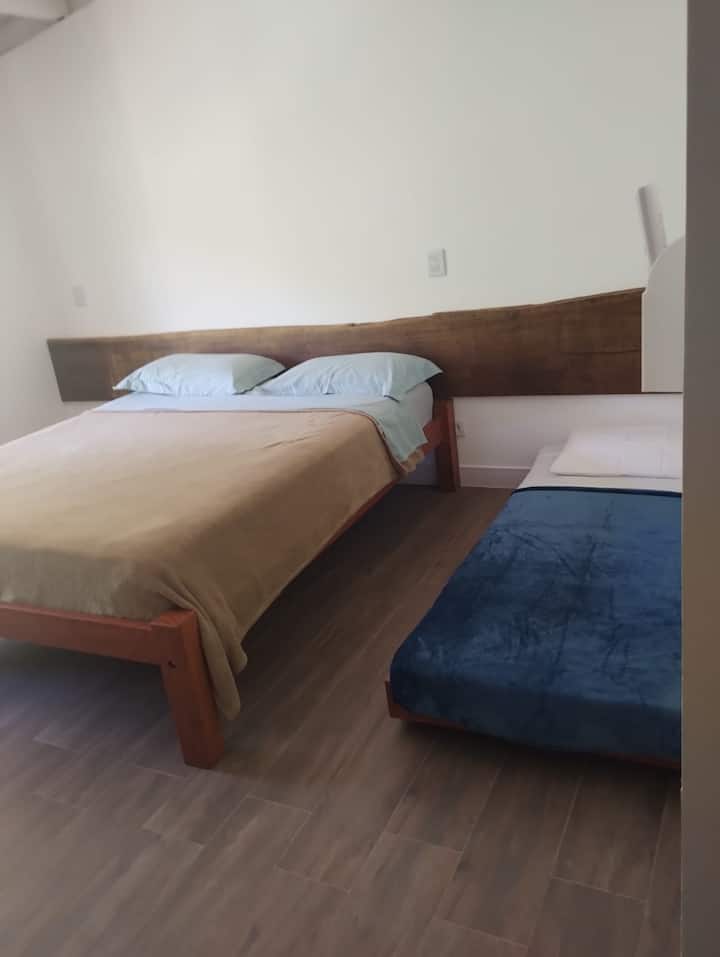 Una habitación espaciosa con 1 cama queen y una cama individual.
Escrivaninha y librería de madera para apoyar las pertenencias.
Juego de cama y baño nuevos y completos.
Aire acondicionado nuevo