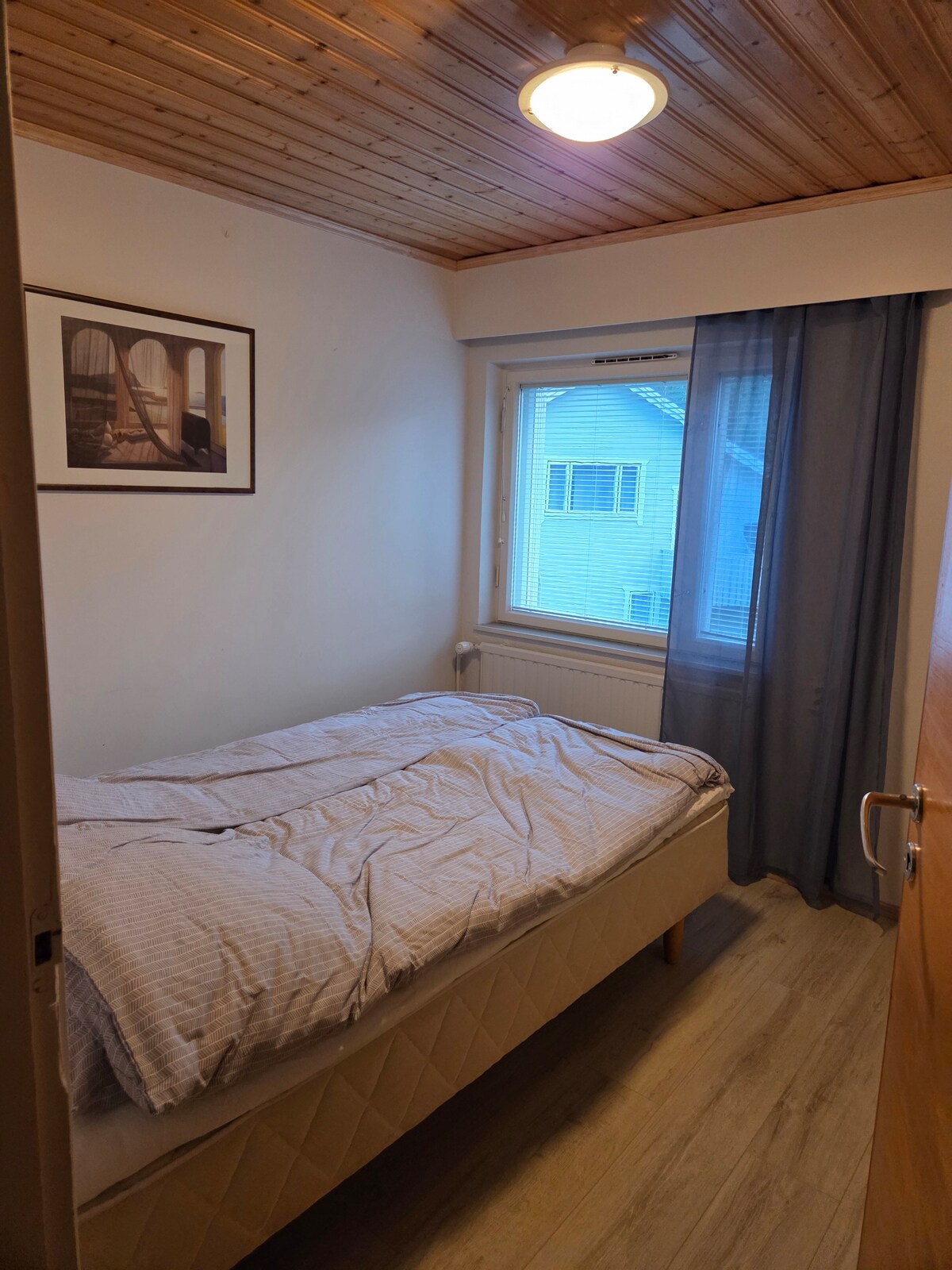 Este dormitorio de arriba tiene una pequeña cama doble. La habitación también tiene un armario para guardar ropa.