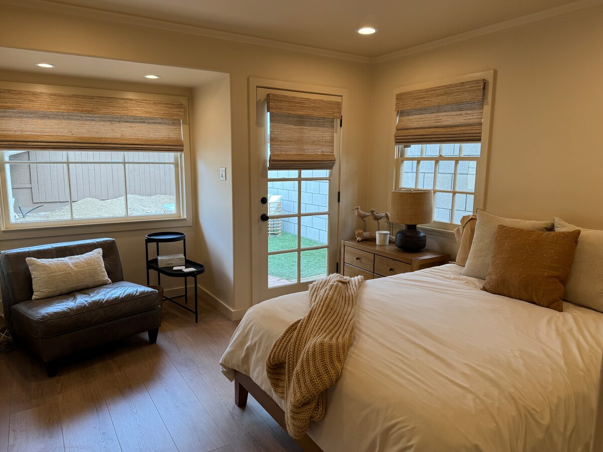 سرير بحجم كوين مع ملاءات قطنية، وسائد ناعمة، تلفزيون مع روكو، ستائر تعتيم للجلوس للقراءة، باب إلى الفناء الخلفي مع مقاعد وطاولة طعام 