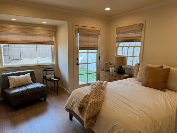 Cama tamaño queen con sábanas de algodón, almohadas de plumón, TV con Roku, persianas opacas, asientos para leer, puerta al patio trasero con asientos y mesa de comedor.