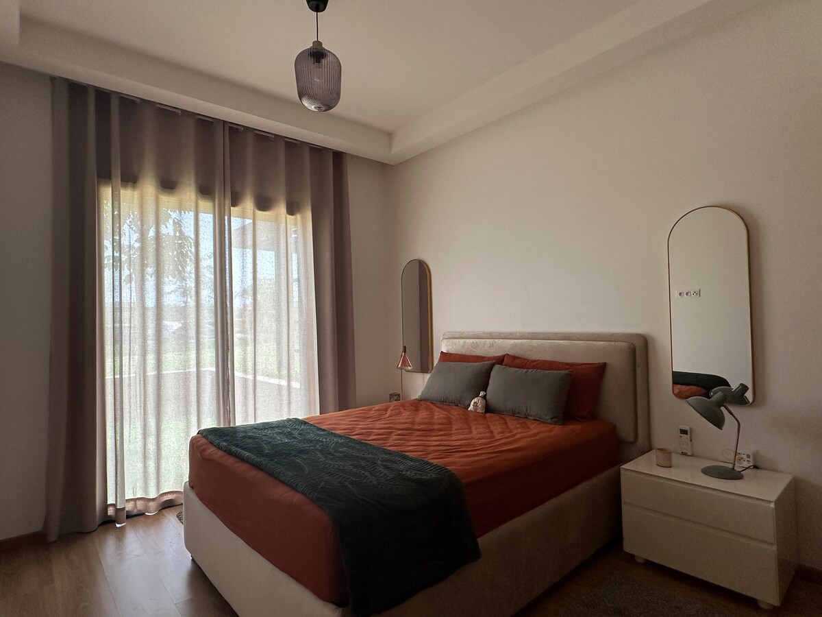 חדר שינה שקט ואלגנטי עם נוף לגינה פרטית, מצויד בארון ועוצב כדי להציע לילות מתוקים באווירה מרגיעה ומעודנת!