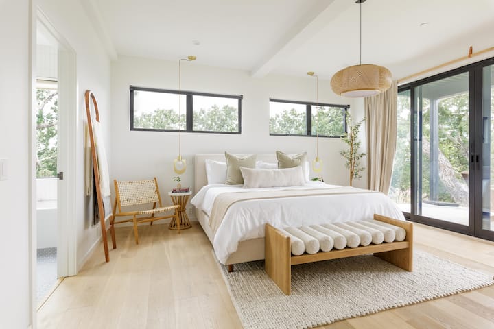 The expansive primary suite sits at the far end of the footprint — complete with King bed, Casper mattress, plush linens, and full ensuite featuring both a shower and tub.
