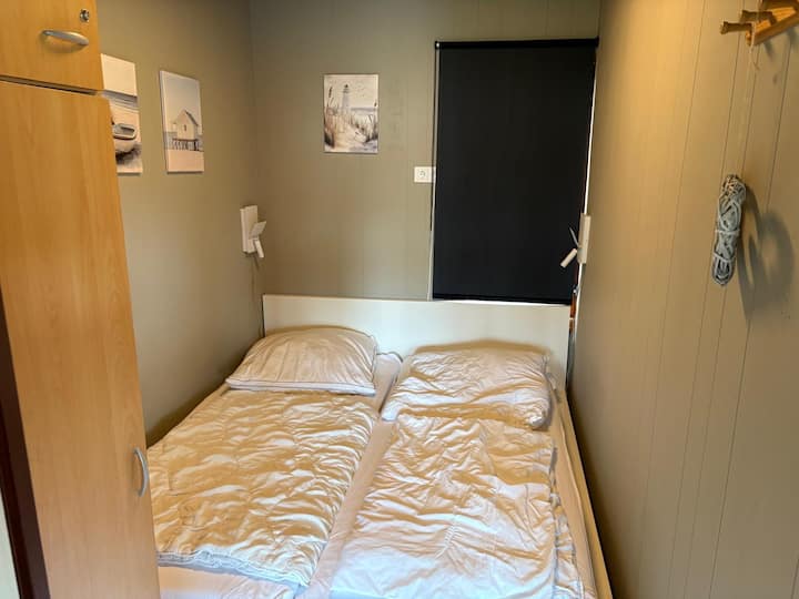 ห้องนอนมีเตียงคู่กว้าง 180 ซม. ความสะดวกสบายในการนอนสำหรับสองคน และยังมีตู้เสื้อผ้าด้วย เหมาะสำหรับพื้นที่เก็บของเพิ่มเติม