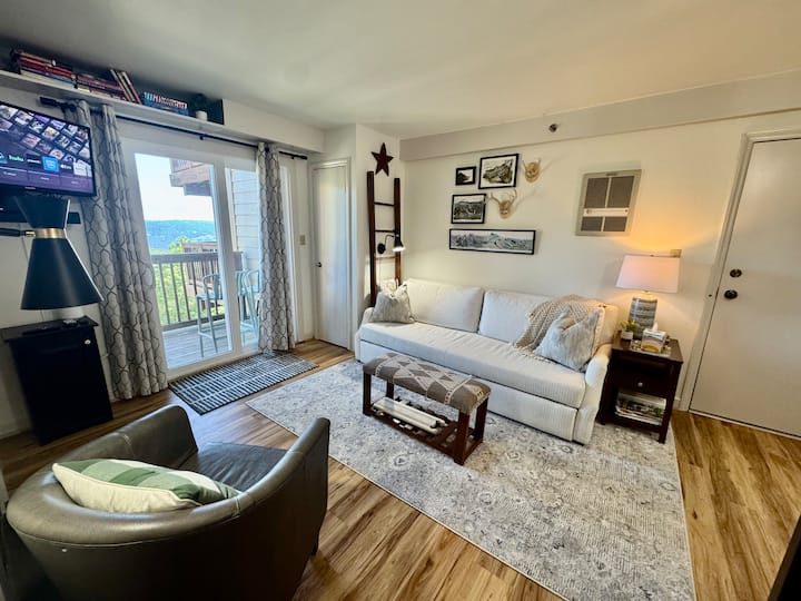 Cómoda sala de estar con televisor inteligente, sofá cama y terraza privada.