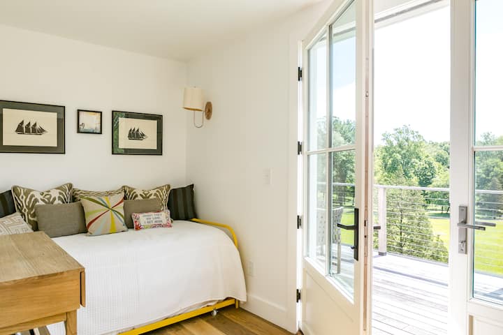 Chambre double lumineuse avec lit gigogne et accès direct à la terrasse du deuxième étage – un espace de couchage flexible idéal pour les enfants, les adolescents ou les voyageurs supplémentaires qui séjournent dans cette retraite des Catskills