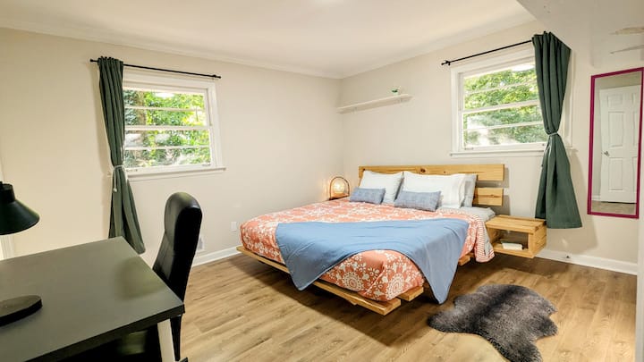 يخلق السرير الكبير ومكتب العمل والحمام الصغير بيئة مثمرة ومهدئة.