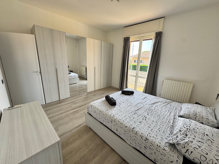 Dormitorio luminoso y tranquilo con un gran armario, una cama acogedora y acceso al balcón. Despierta con la luz del sol y las brisas suaves: un refugio tranquilo diseñado para el verdadero descanso y la comodidad. Hay espacio para un colchón de aire adicional o una cuna.