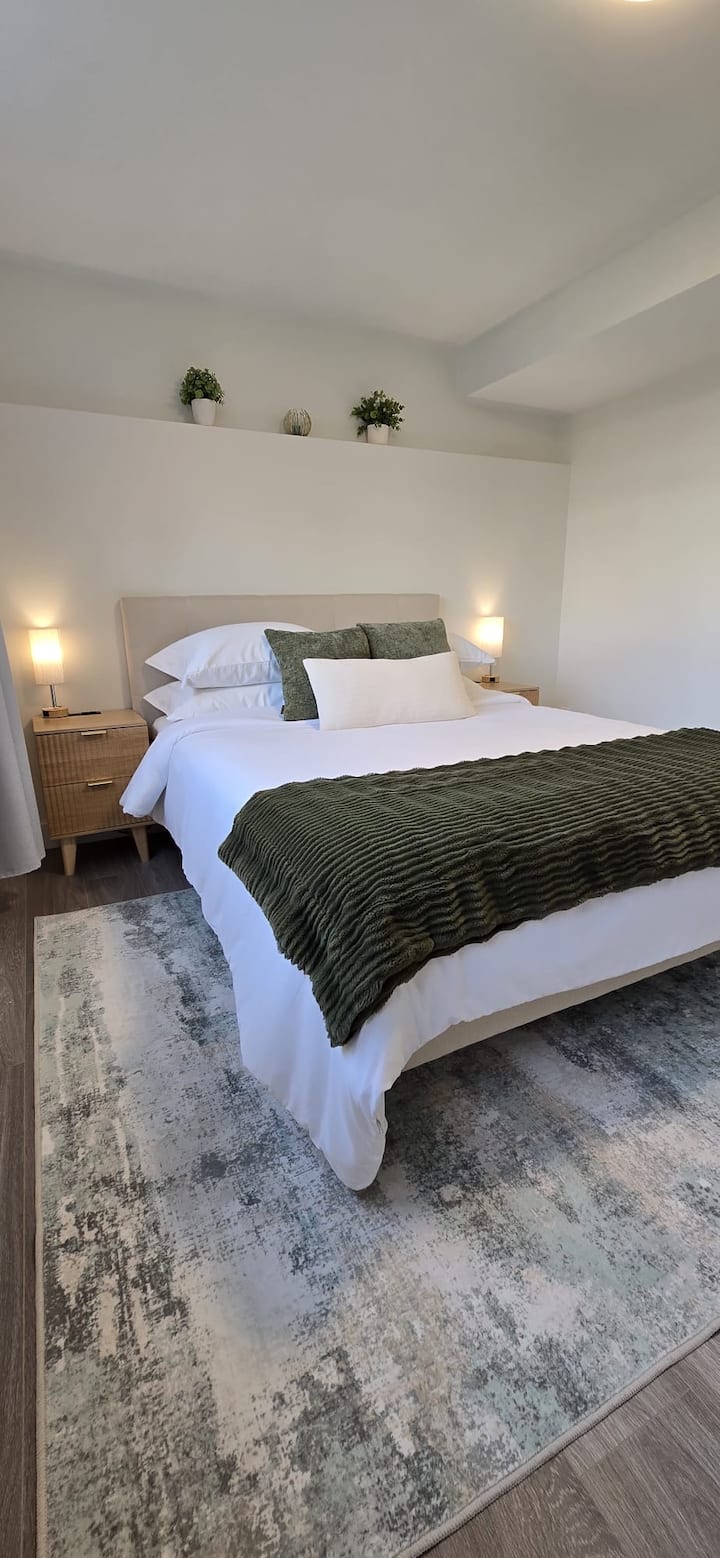 Cama tamaño queen con cortinas opacas y puertos de carga.
