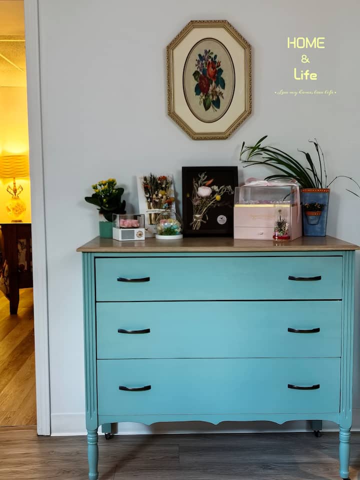 Siente la paz con la elegancia vintage, esta encantadora cómoda de pino centenaria con una elegante artesanía vintage, pintada en un suave color turquesa y adornada con flores preservadas para siempre, es perfecta para aquellos que aman el encanto atemporal y los detalles acogedores.