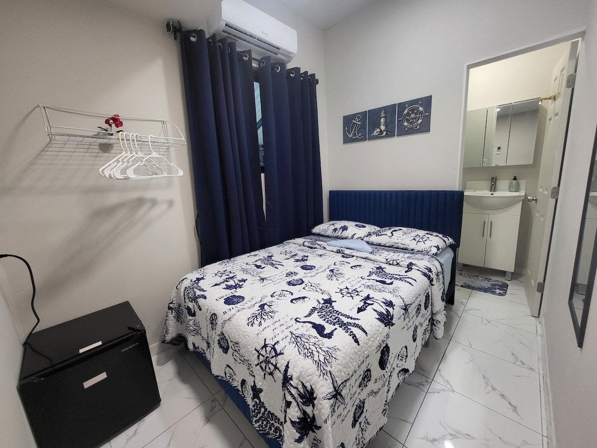 Dormitorio extremadamente pequeño con baño privado pequeño adjunto.