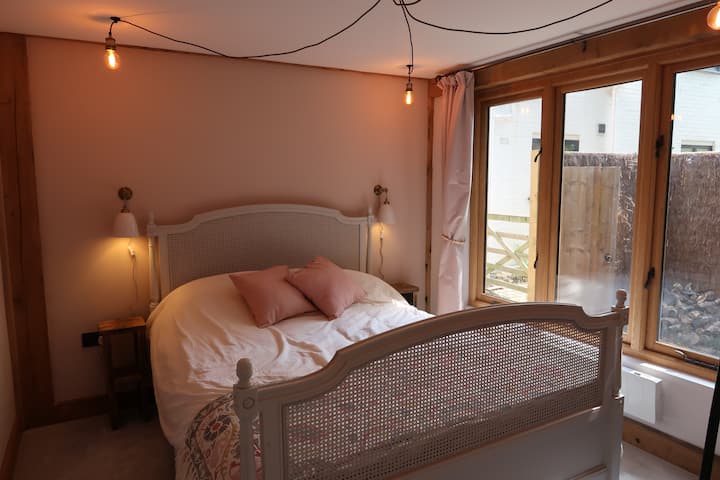 Спалня с удобно легло с кралски размер, полилеи, място за окачване на дрехи, огледало и сешоар.