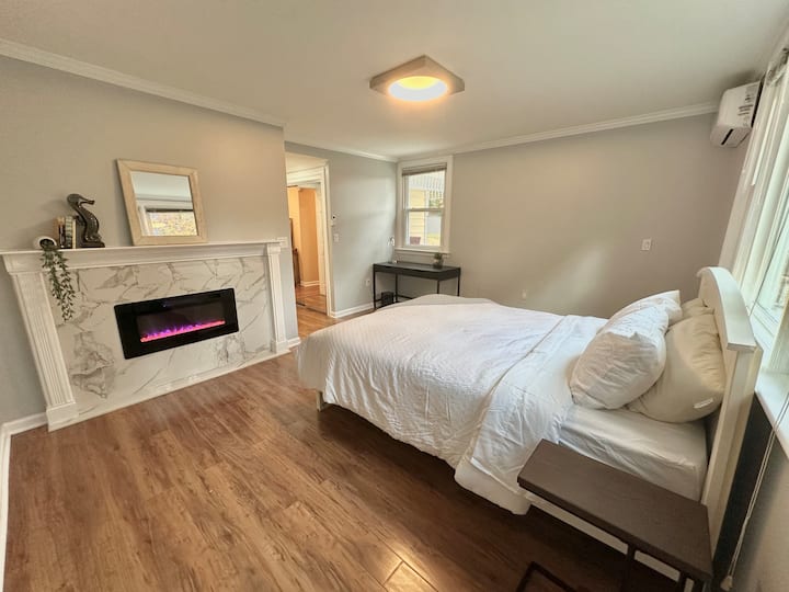 استمتع بغرفة نوم أساسية دافئة ومريحة مع مدفأة ستضفي أجواء لقضاء عطلة مريحة 