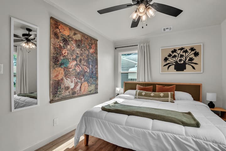 Оваа мирна спална соба има кадифен брачен кревет, меко светло на прозорецот со завеси што течат, елегантно ѕидно огледало и минималистичко ноќно шкафче дизајнирано за мирни ноќи и бавни утра.
