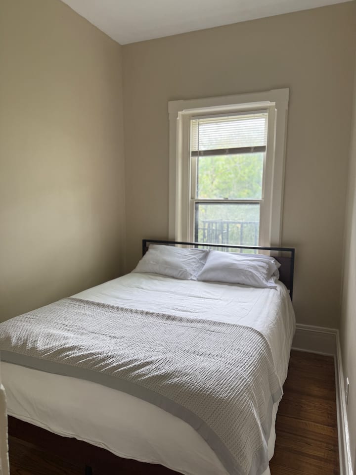 Kitanda cha starehe chenye tani zisizoegemea upande wowote na mashuka laini