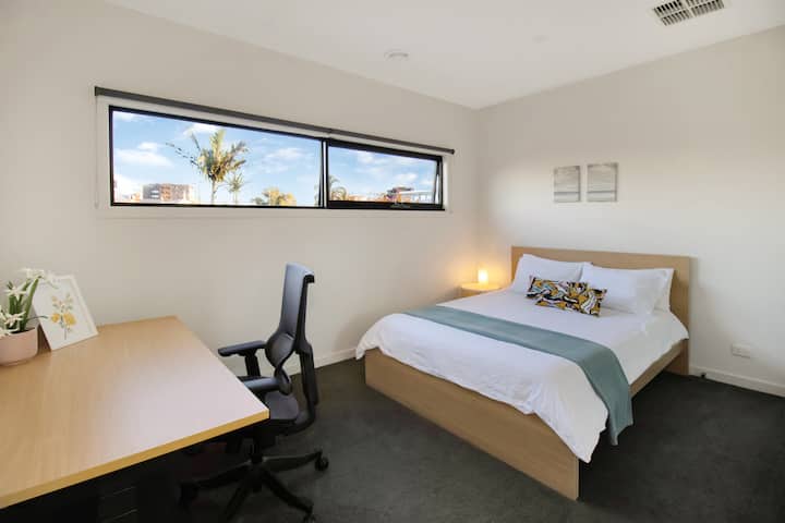 Recámara luminosa con espacio de trabajo, luz natural y un ambiente acogedor y moderno