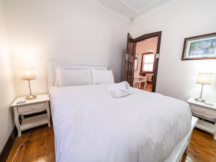 Chambre confortable et lumineuse avec un lit queen size moelleux, des draps frais et un éclairage chaleureux. Profitez d'un décor charmant, de sols en bois poli et d'un espace paisible parfait pour se détendre. Idéal pour les couples ou les voyageurs seuls à la recherche de confort et de style.