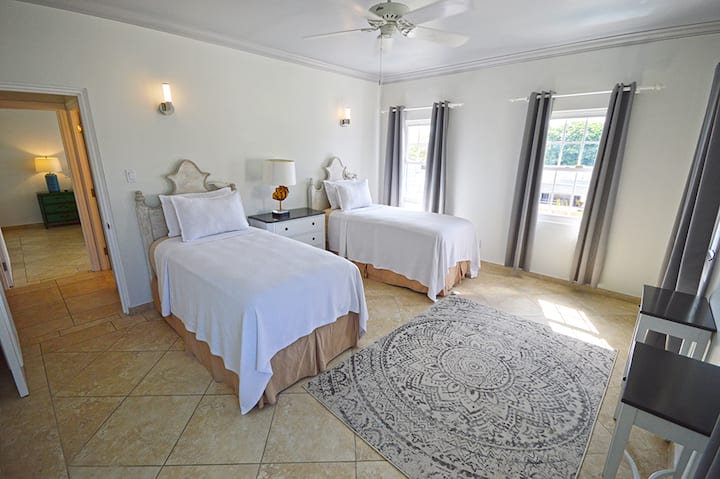 غرفة نوم في الطابق العلوي بسريرين متماثلين يمكن تجميعهما معًا كملك 