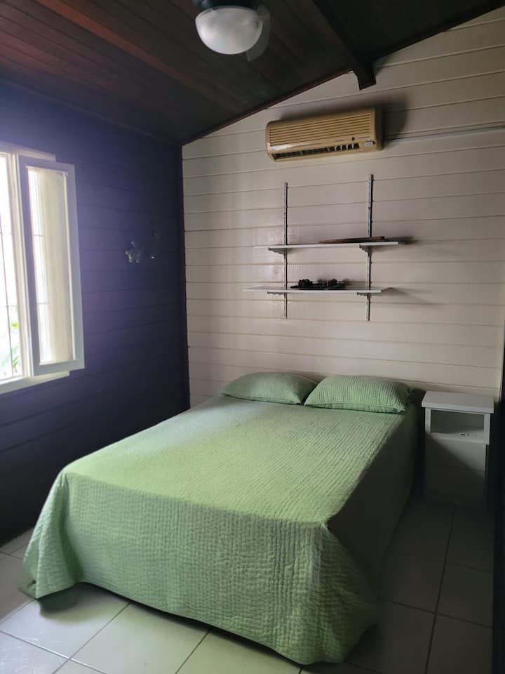 Spavaća soba s bračnim krevetom, klima-uređajem i stropnim ventilatorom.