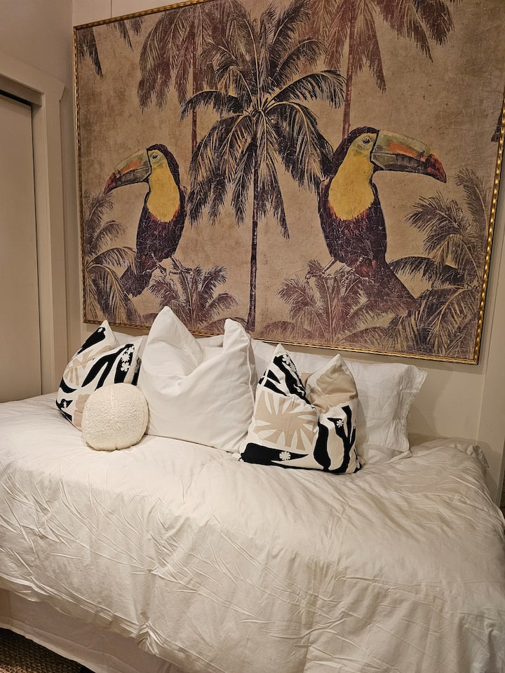 ห้องนอนแขกนี้ตั้งอยู่ใจกลางอพาร์ทเมนท์ มีงานศิลปะขนาดใหญ่ผิดปกติที่ทำจากกระดาษวินเทจ ซึ่งใช้เป็นหัวเตียงสำหรับเตียงเดย์เบดขนาดคู่นี้ แต่ที่สำคัญกว่านั้นคือมันสร้างบรรยากาศเขตร้อนที่สนุกสนาน ถอดรองเท้าออกและผ่อนคลาย 