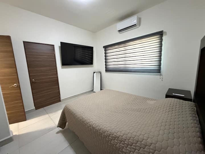 Recamara 1 con TV, A/C, cama, dos buros y baño completo